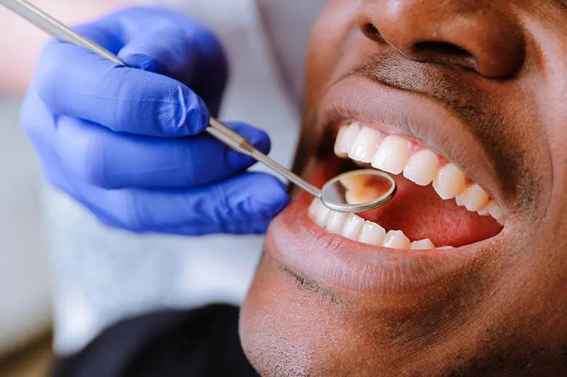 a patient's teeth with a mouth mirror
